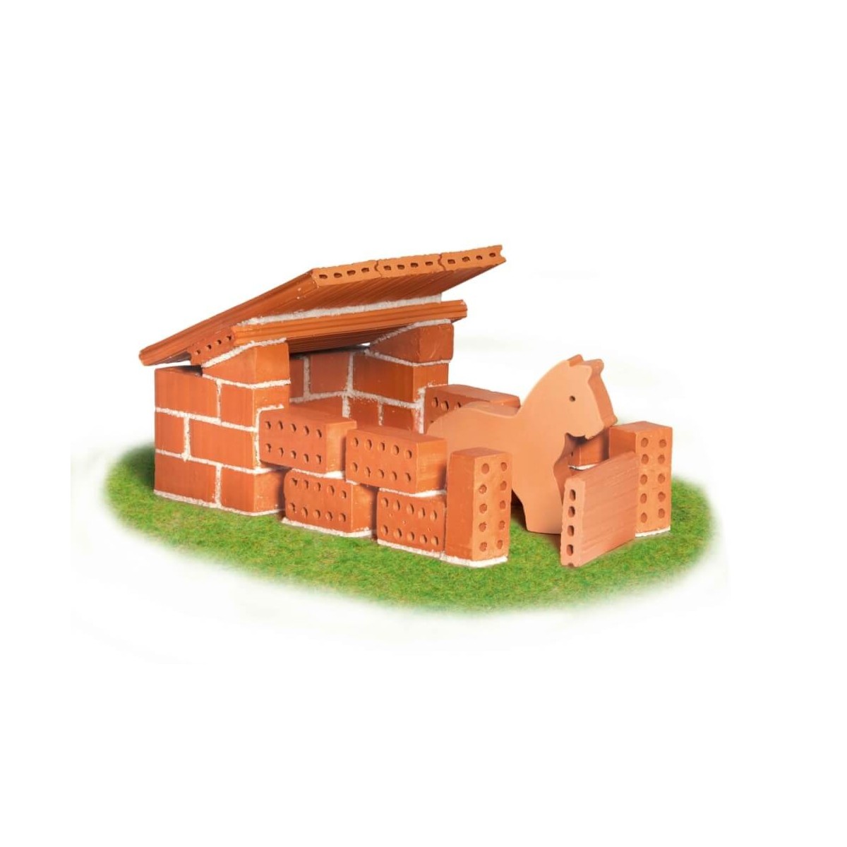 Miniatur-Bausteine und eine Pferdefigur sind auf grünem Gras zu einem kleinen Stall arrangiert.