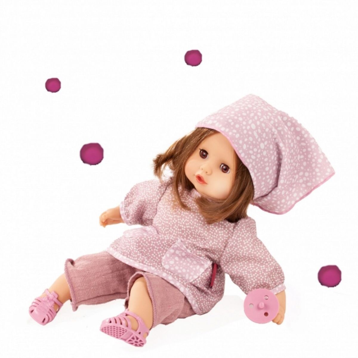 Braunhaarige Puppe im rosa Schlafanzug und Mütze mit rosa Schnuller, umgeben von lilafarbenen Punkten. Braunhaarige Puppe im rosa Schlafanzug und Mütze mit rosa Schnuller, umgeben von lilafarbenen Punkten.