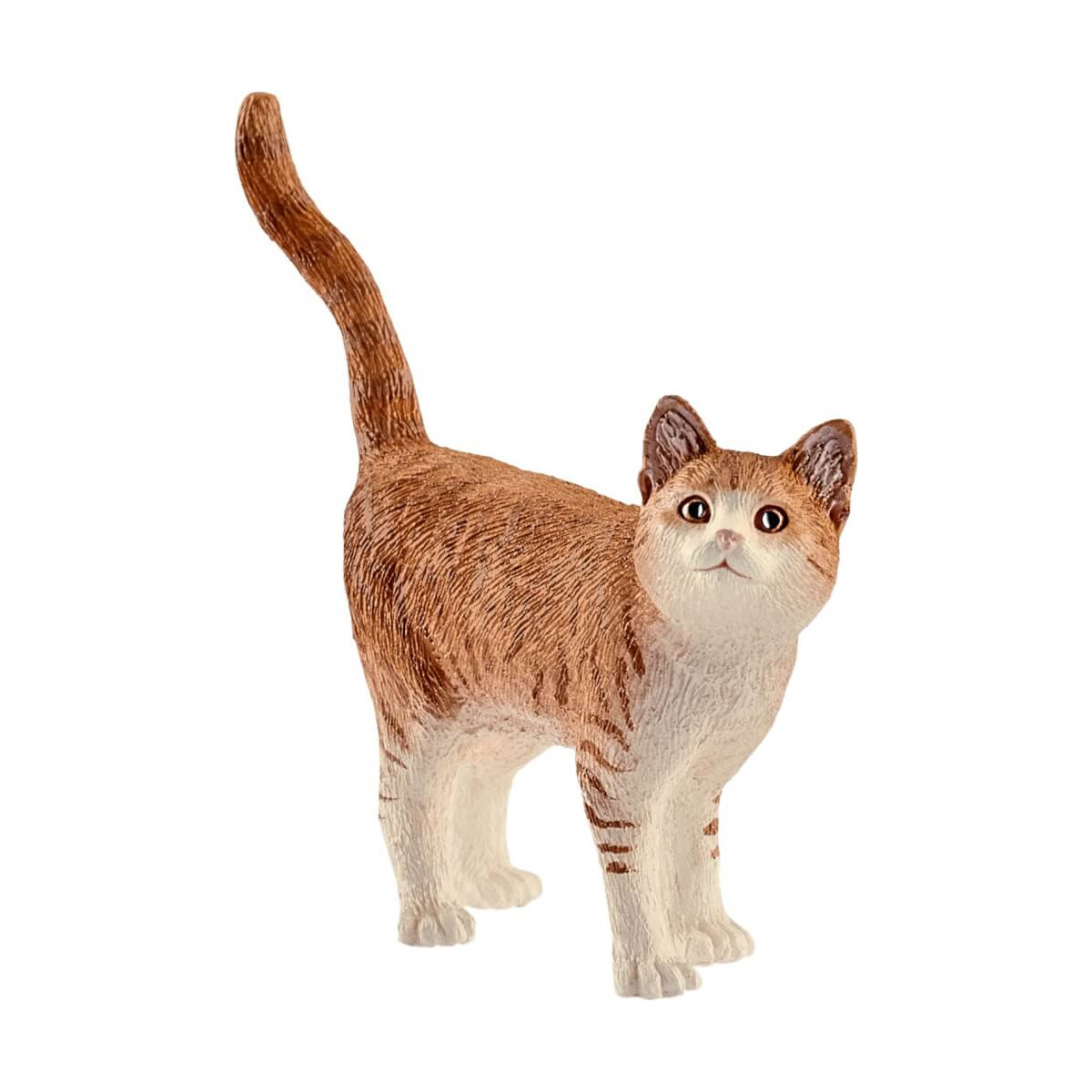 Kleine braun-weiße Katzenfigur steht mit erhobenem Schwanz und blickt nach vorn.