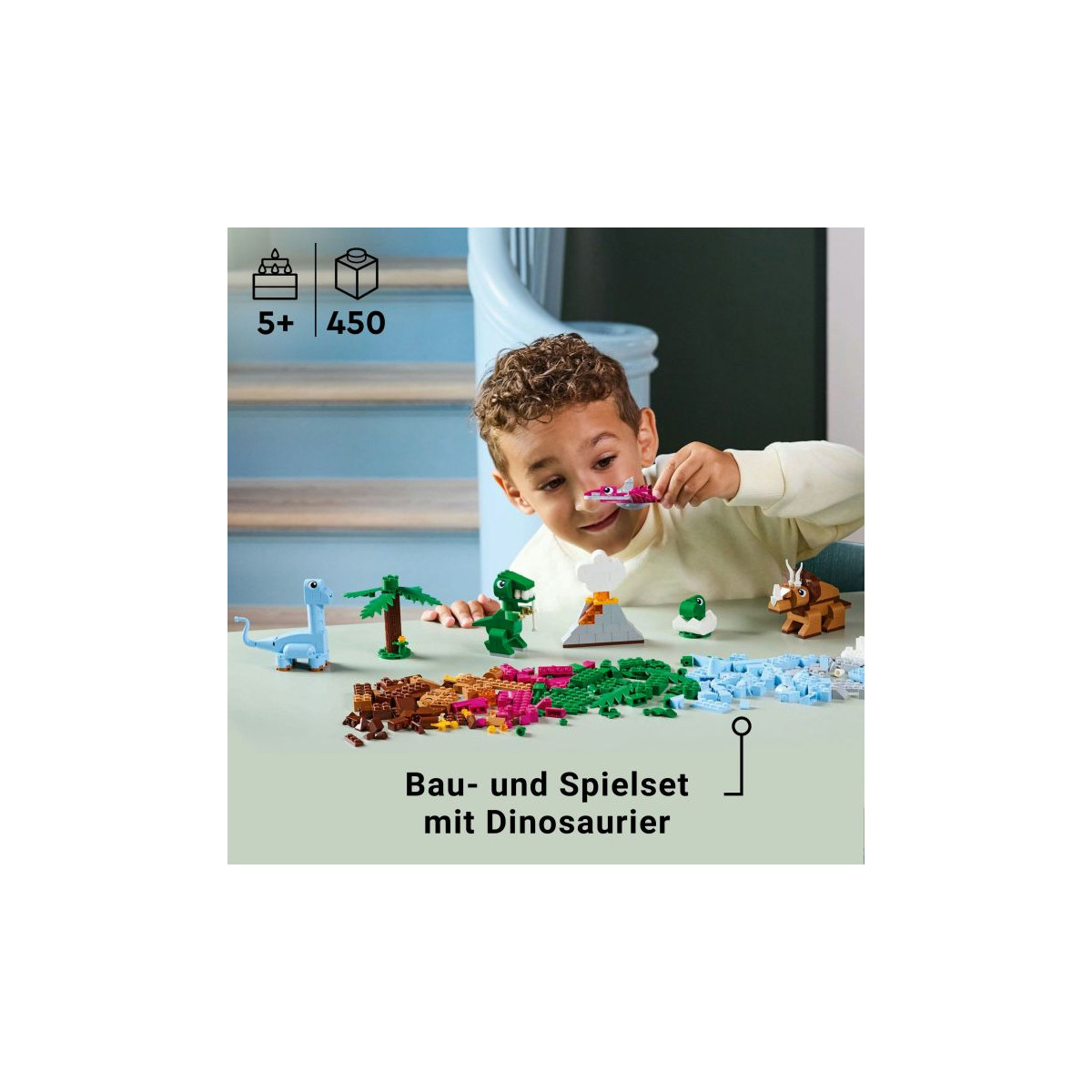 Lächelndes Kind spielt am Tisch mit bunten Dinosaurier-Bausteinen, darüber steht deutscher Text.