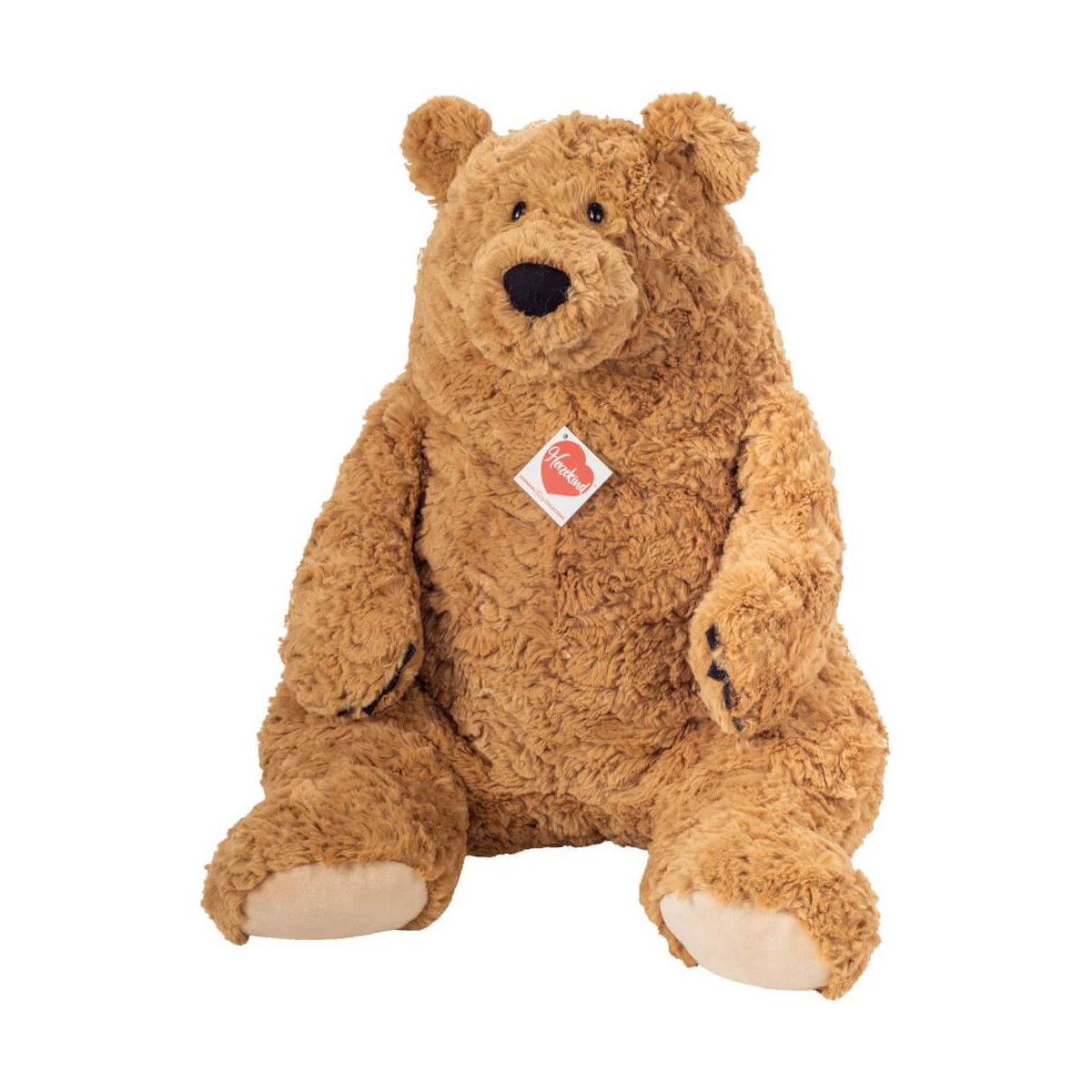 Großer, brauner Plüsch-Teddybär mit Brustetikett sitzt aufrecht vor weißem Hintergrund.