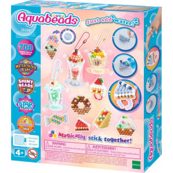 Aquabeads Bastelset mit bunten Perlenkreationen und Anleitung auf rosa-blauem Hintergrund.