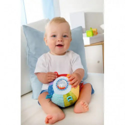Bunter, strukturierter Baby-Sensorikball mit Schlaufen, Etiketten und Rasselfenster vor weißem Hintergrund.